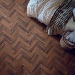 Chicory haze effect herringbone LVT flooring laid in a bedroom