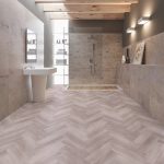 Heather grey effect herringbone LVT flooring laid in a bathroom